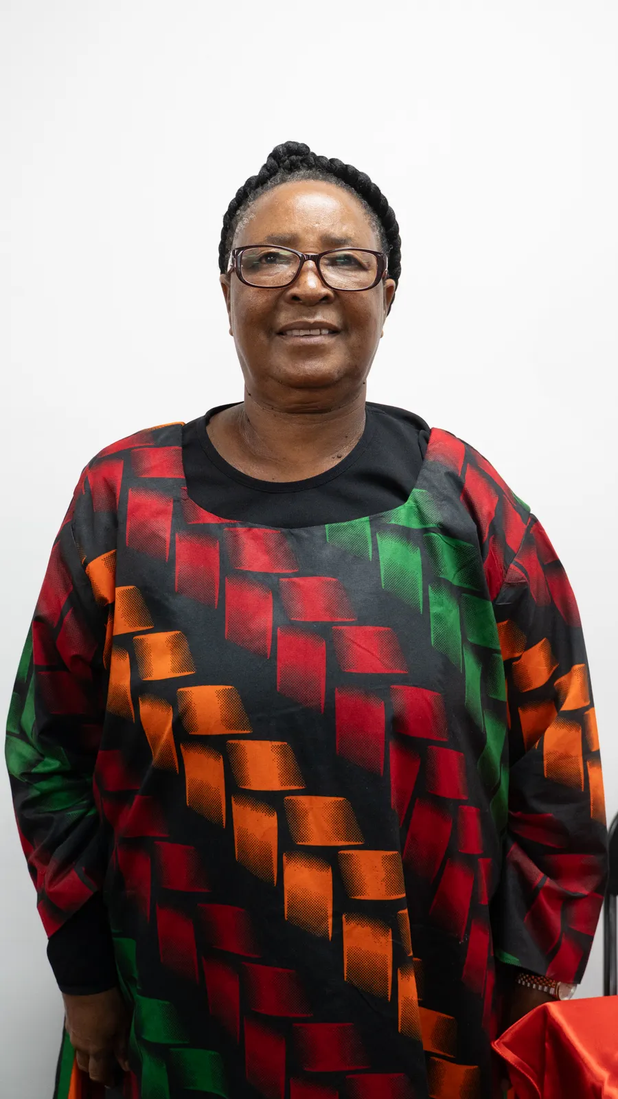 A woman in a red, green and black patterned dress at a Black History Month gathering.