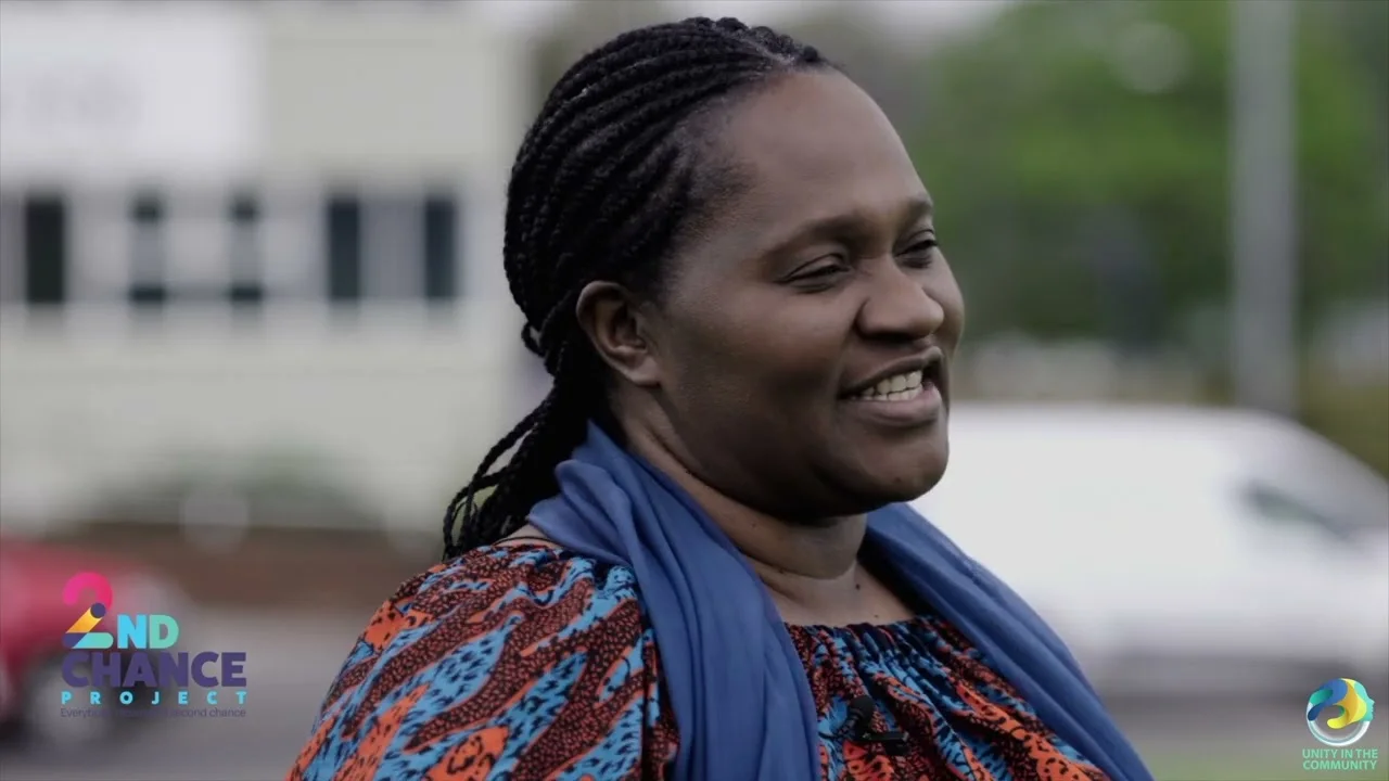 Faith Gakanje-Ajala speaking outdoors during a community project interview.